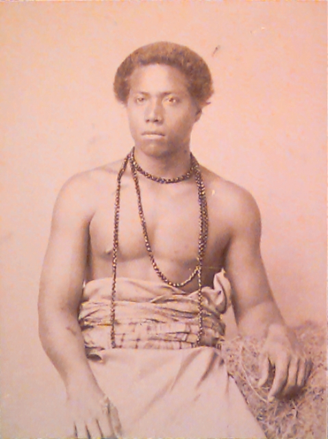 A historical black and white photo of a young Samoan man